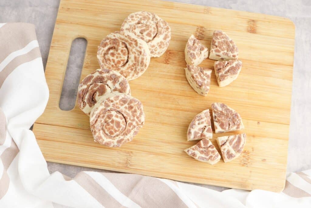 Cinnamon rolls on wooden chopping board.
