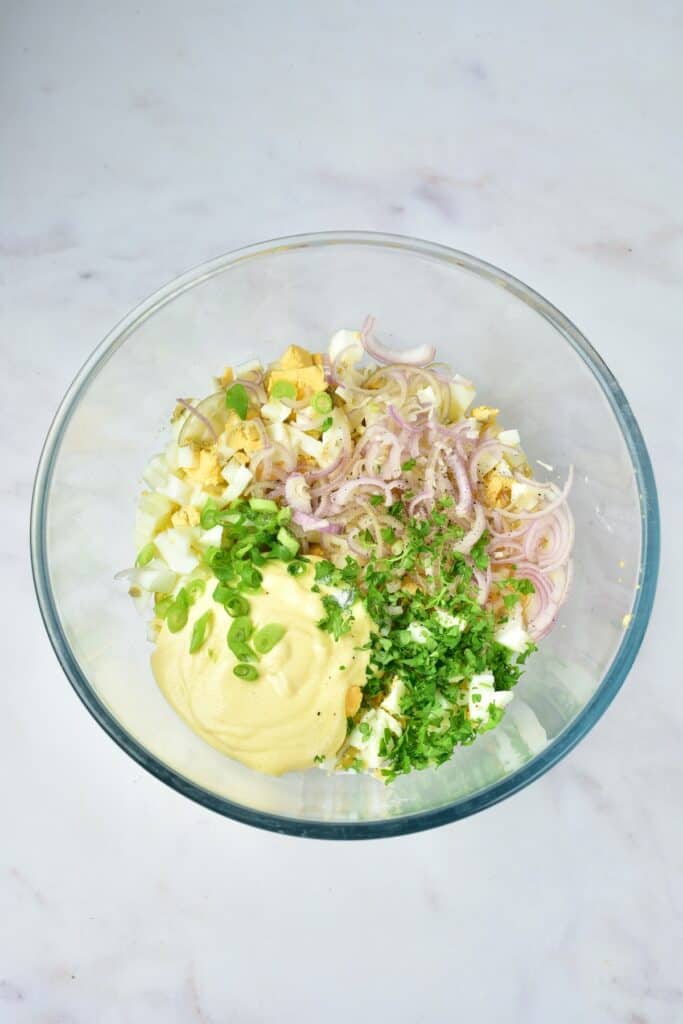 Egg salad ingredients in mixing bowl, overhead shot.