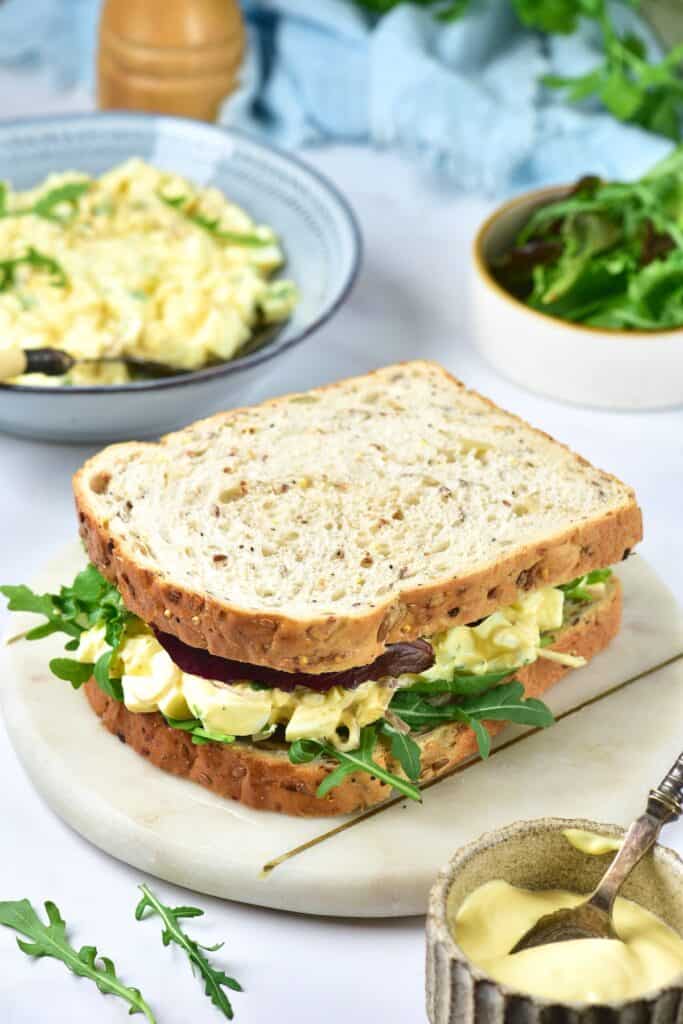 Egg salad sandwich on marble tray.