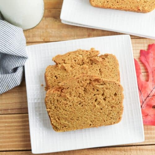 Cake Mix Pumpkin Bread slices on square white plate with decorative fall leaf.