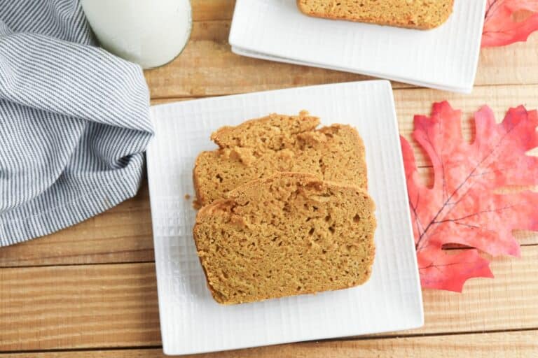 Cake Mix Pumpkin Bread slices on square white plate with decorative fall leaf.