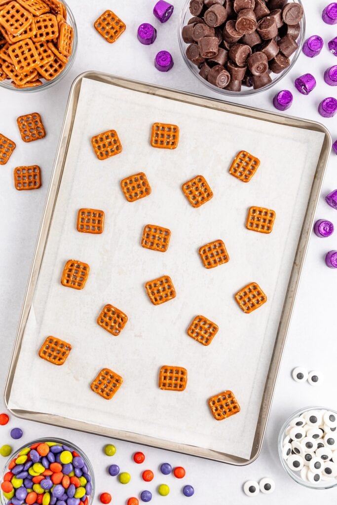 Halloween Rolo Pretzels in process, pretzels only, on baking tray, overhead shot.