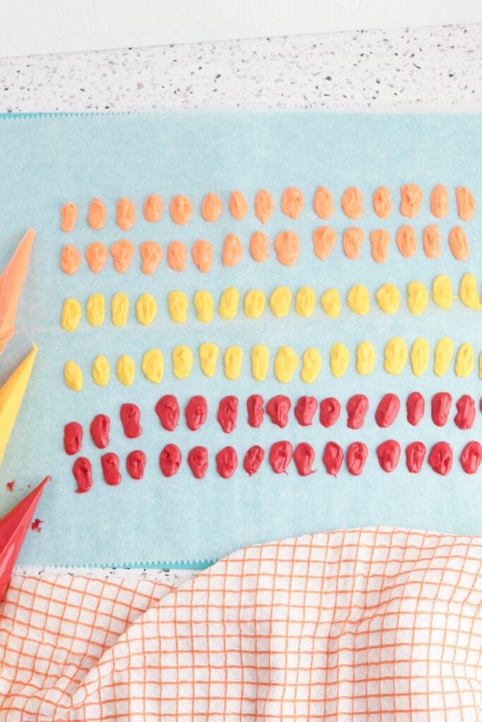Mini Turkey Cupcakes, in process overhead shot of feather candy melts on parchment paper.