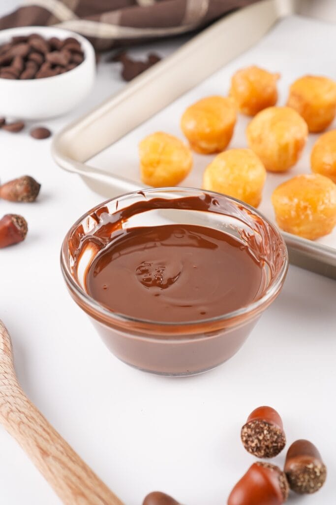Acorn Donut Holes, in process, chocolate chips, melted in bowl.