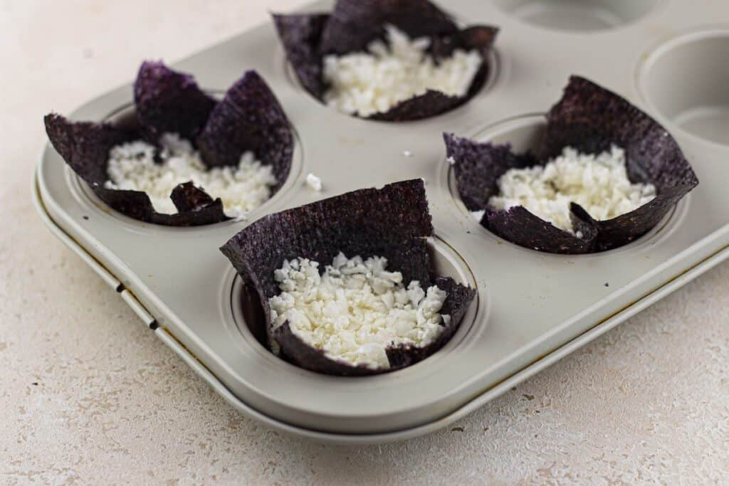 Baked Salmon Sushi Cups, in process, nori squares with cauliflower rice in muffin pan.