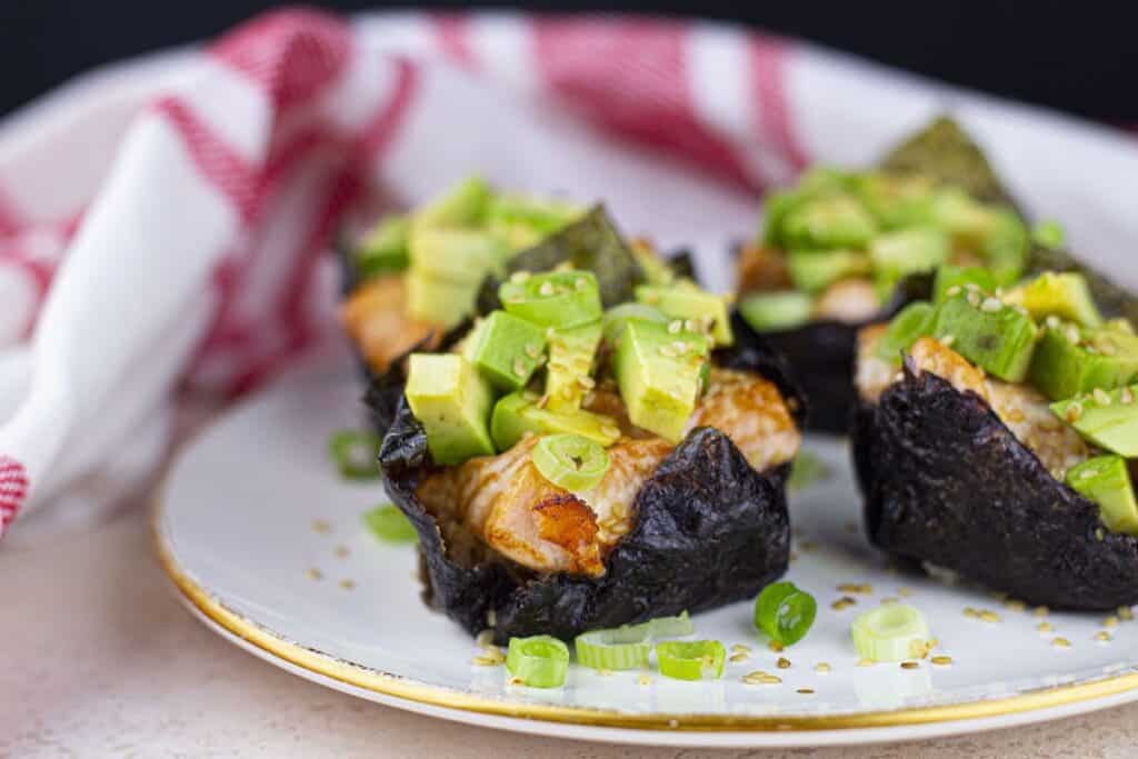 Baked Salmon Sushi Cups, plated and close-up, with red striped kitchen towel.