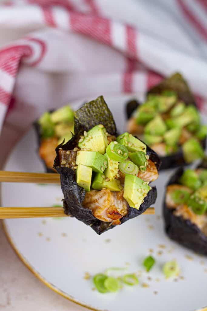 Baked Salmon Sushi Cups, sushi piece held with chopsticks.