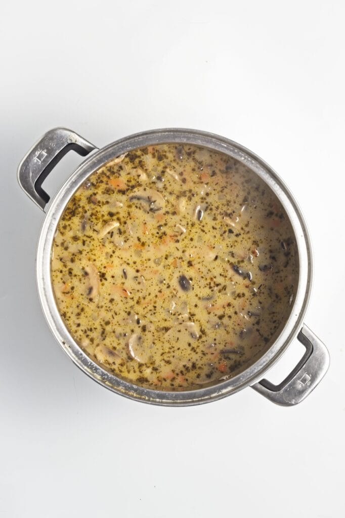 Creamy Mushroom Wild Rice Soup, in process, oat milk mixed into soup in stock pot.