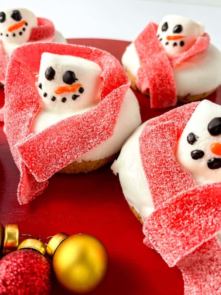 Melted Snowman Donuts on round red tray.