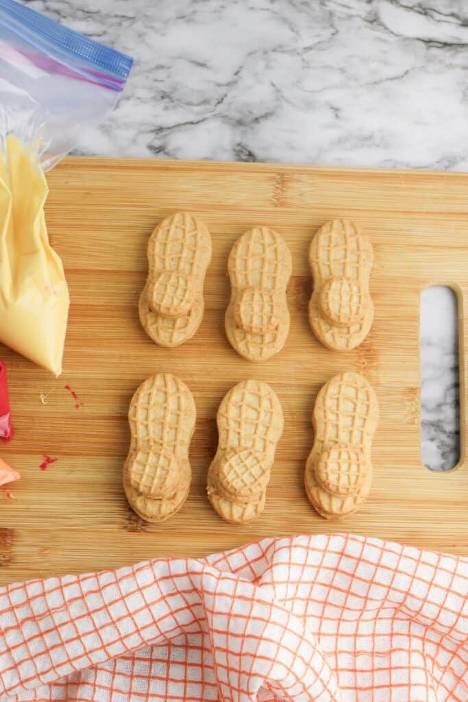 Nutter Butter Turkey Cookies, in process, Nutter Butters and Nutter Butter Bites on wooden cutting board.