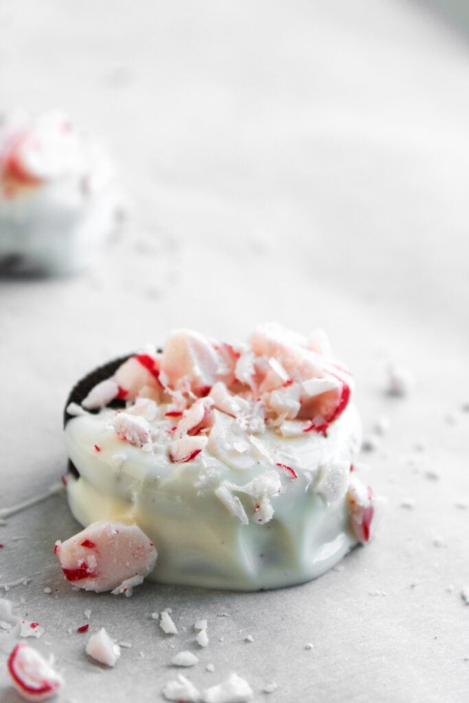 Peppermint Chocolate Covered Oreos, close-up of Oreo covered in white chocolate and crushed peppermint candies.