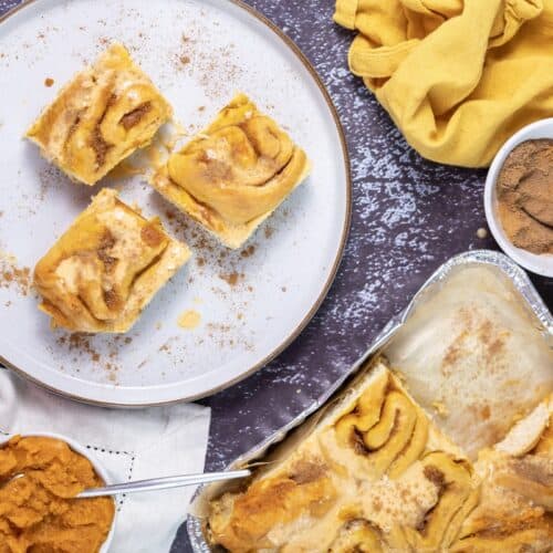 Pumpkin Cinnamon Rolls, on plate, with ingredients in bowls, overhead shot.