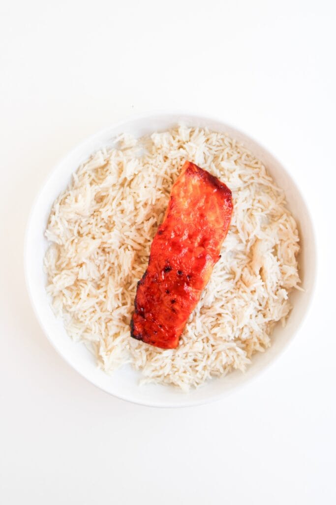 Spicy Salmon Bowl, in process, cooked salmon and rice layer in bowl.