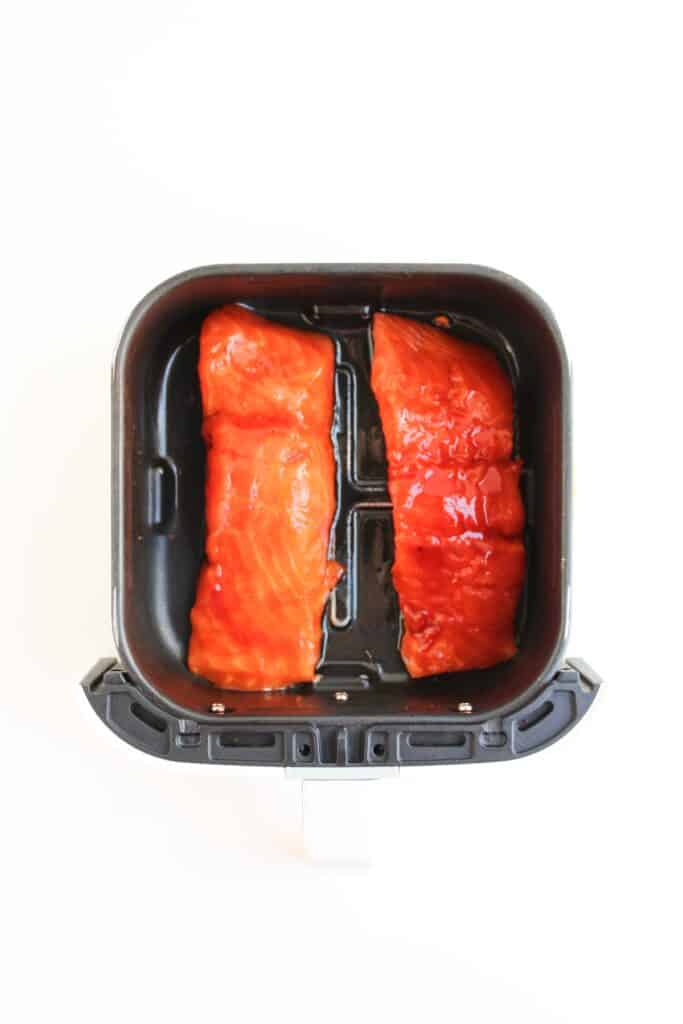 Spicy Salmon Bowl, in process, seasoned salmon in air fryer container, ready to cook.
