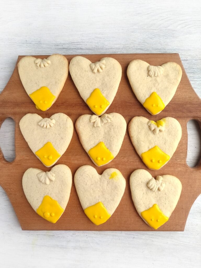 Turkey Sugar Cookies, in process, heart-shaped cookie dough with yellow piped onto cookies.