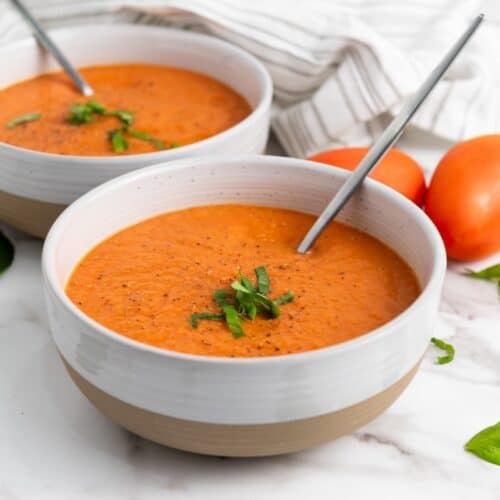 Vegan Roasted Tomato Basil Soup in bowls with spoons.