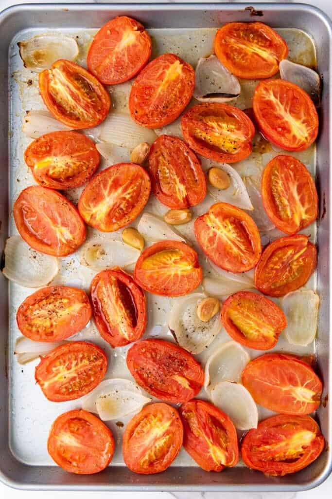 Vegan Roasted Tomato Basil Soup, in process, baked tomato halves with onions, garlic and olive oil on baking sheet, baked.