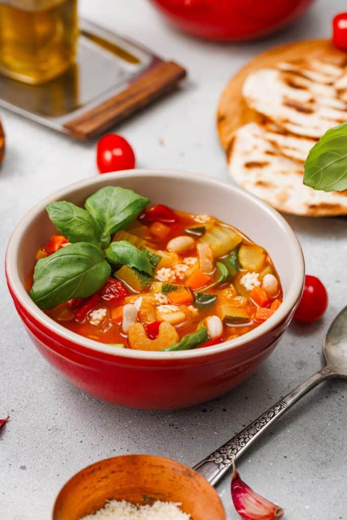 Veggie Minestrone Soup in bowl with basil on top.