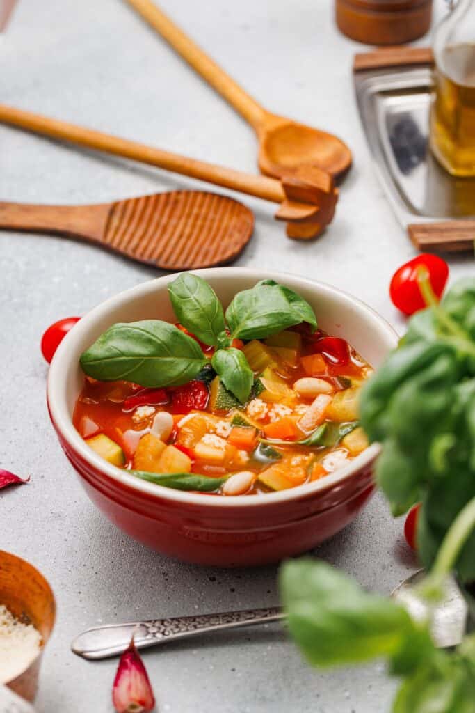 Veggie Minestrone Soup in bowl with basil on top.