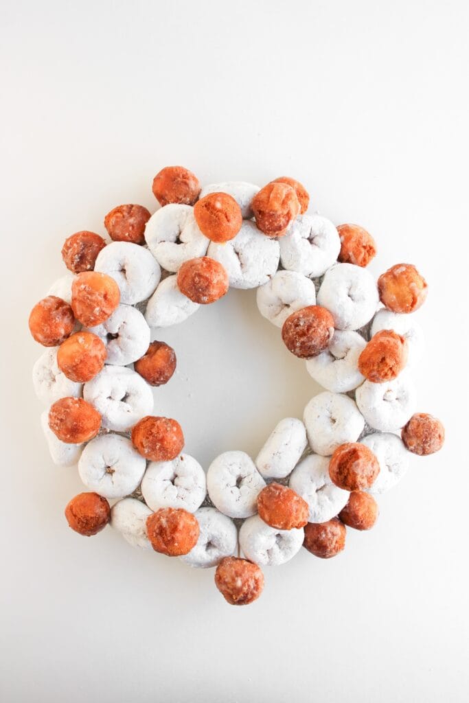 Christmas Donut Wreath, in process, mini powdered donuts and donut holes added to foil.