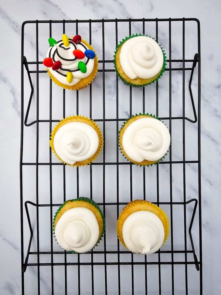 Christmas Light Cupcakes, in process, cupcakes on wire rack ready to have string lights piped onto the frosting.