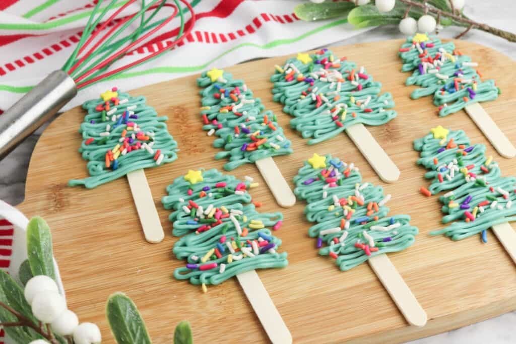 Christmas Tree Pops on wooden cutting board.