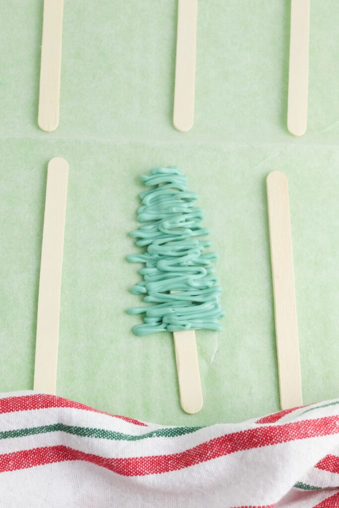 Christmas Tree Pops, in process, green candy triangle on popsicle stick.