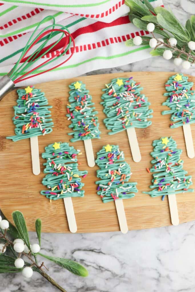 Christmas Tree Pops on wooden cutting board.