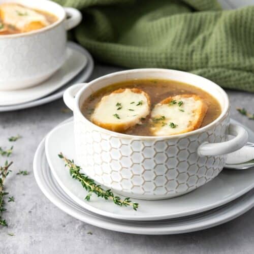 French Onion Soup with cheesy baguette slices in bowl of soup.