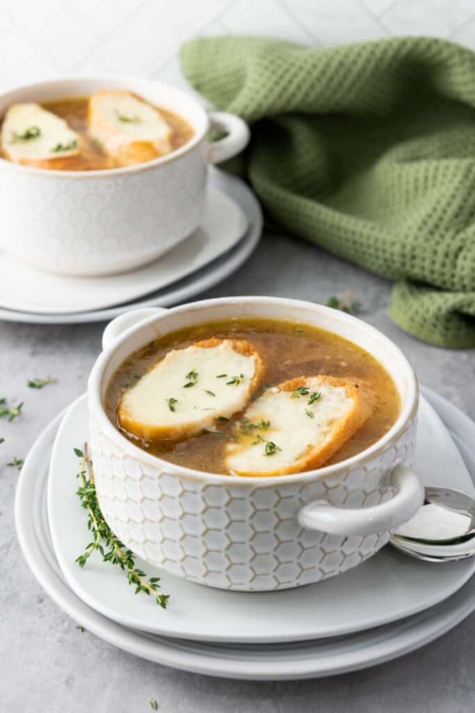 French Onion Soup with cheesy baguette slices in bowl of soup.