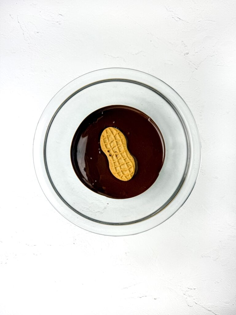 Nutter Butter Owl Cookies, in process, Nutter Butter cookie in melted chocolate.