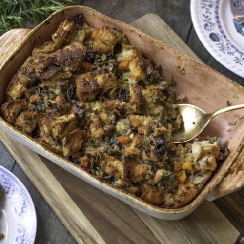 Homemade Herb and Vegetable Stuffing in baking dish with serving spoon.