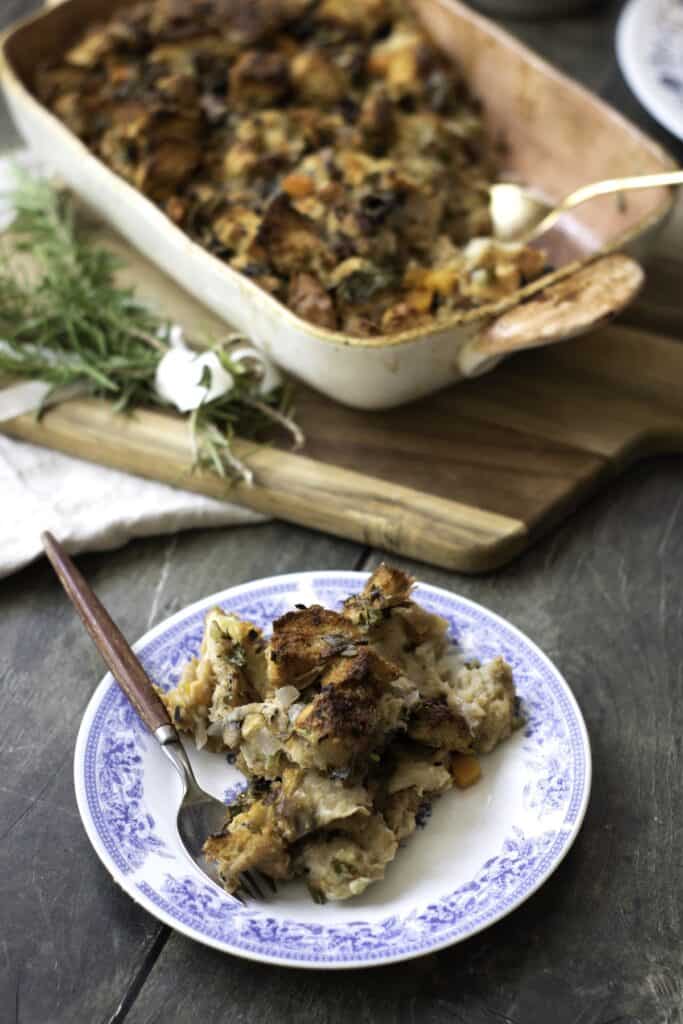 Homemade Herb and Vegetable Stuffing in dish with plated stuffing.
