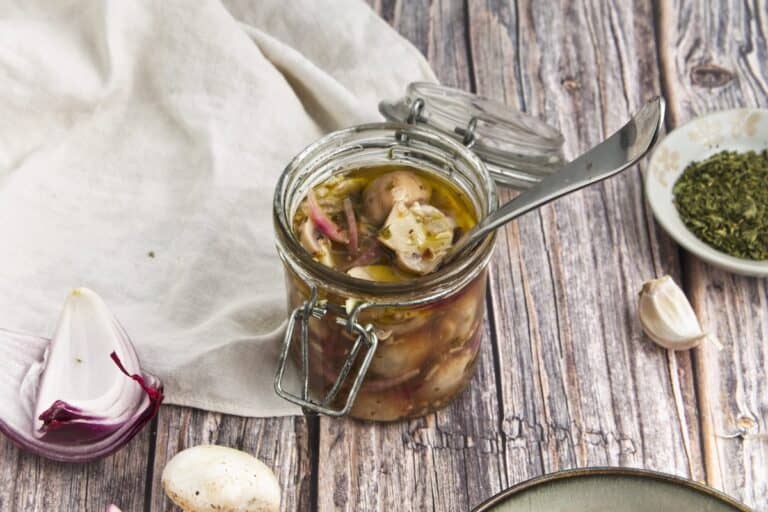 Marinated Mushrooms in mason jar on wood background.