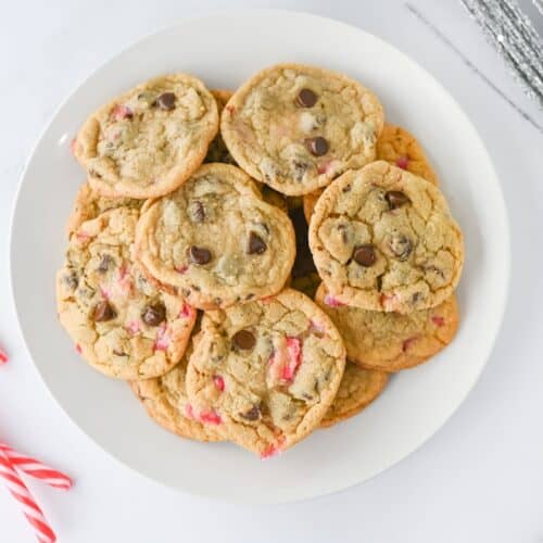 Peppermint Chocolate Chip Cookies on white plate next to candy canes.