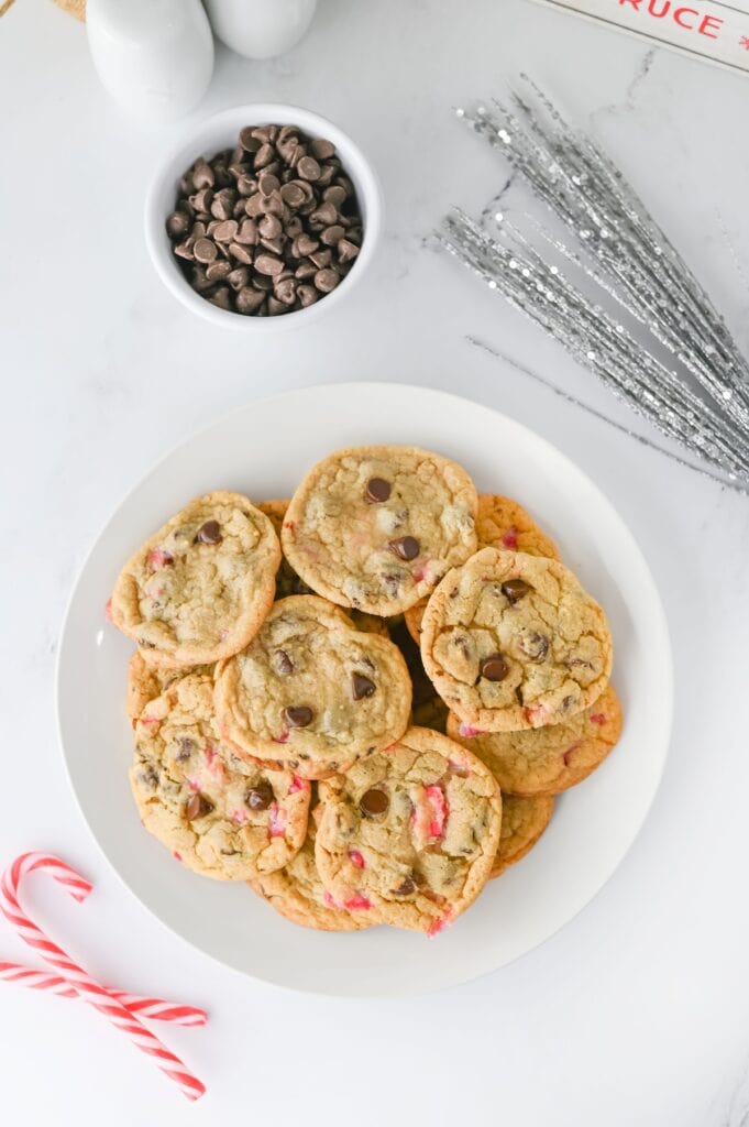Peppermint Chocolate Chip Cookies on white plate next to candy canes.