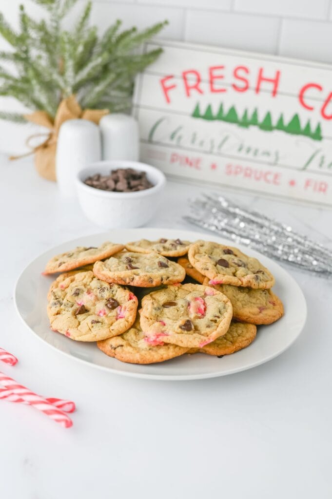 Peppermint Chocolate Chip Cookies on white plate next to candy canes.